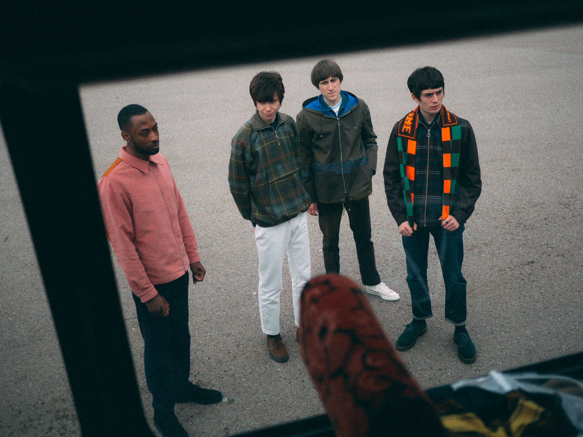 Four models wearing Anglozine jackets and trousers, viewed from above.